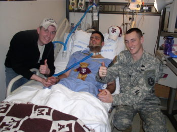 Aggies Dustin Greene (left) and Jonathan Murphy (right), join an injured Jordan Enger at his bedside.