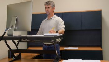 Man using stand up desk in office for good health
