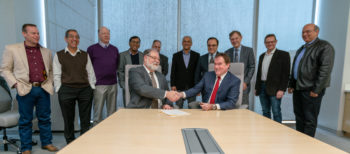 Mark A. Barteau, vice president for research at Texas A&M University, shakes hands with Robert Watkins, director of the Jet Propulsion Laboratory, after signing a three-year strategic partnership between the institutions. Standing are representatives from the laboratory and faculty members from Texas A&M’s colleges of engineering, science and geosciences.