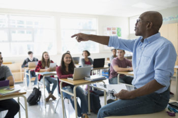 High school teacher calling on student in classroom