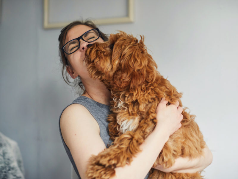 Woman getting a kiss from her pet dog