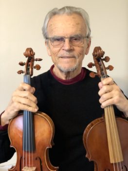 Joseph Nagyvary holding two violins