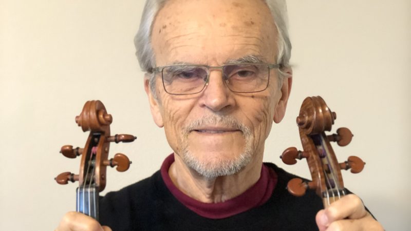 Joseph Nagyvary holding two violins