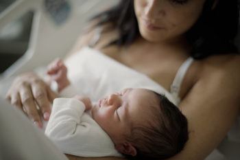 Newborn girl sleeps in her mother's arms