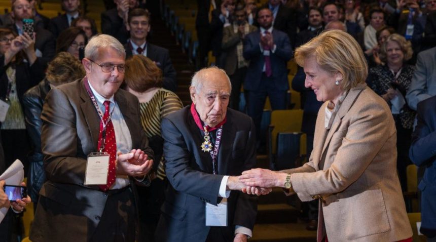 Princess Astrid congratulates former Aggie corpsman William Merriweather Peña ’42 after awarding him the Order of the Crown medal as the audience stood and applauded.