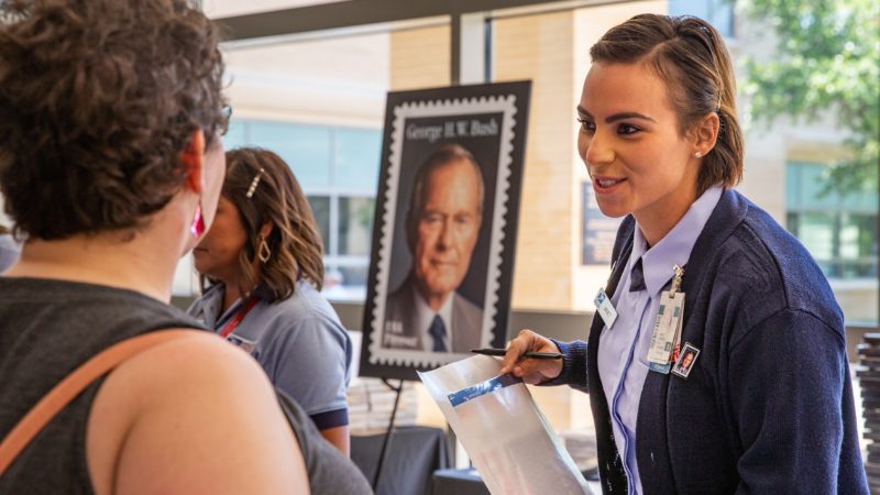 U.S. Postal Service members sell stamps to attendees of the first-day-of-issue ceremony at the Annenberg Presidential Conference Center.