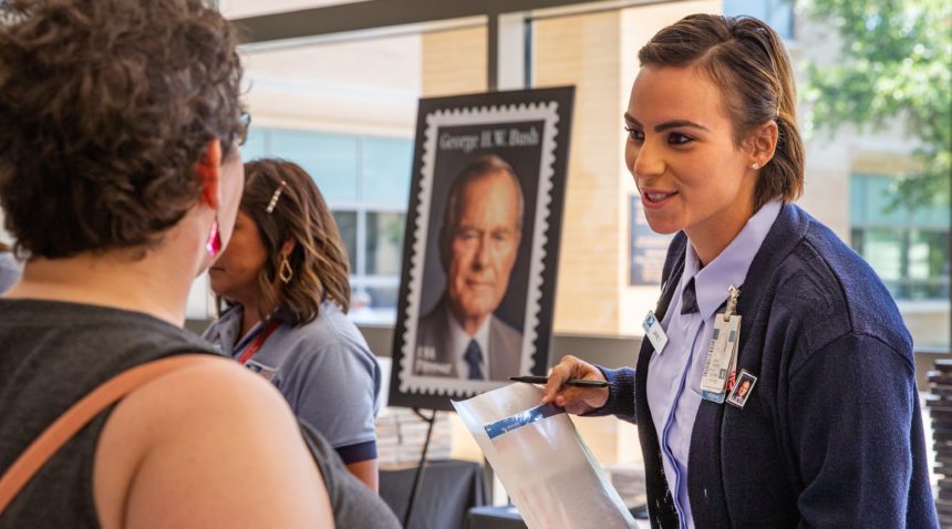 U.S. Postal Service members sell stamps to attendees of the first-day-of-issue ceremony at the Annenberg Presidential Conference Center.