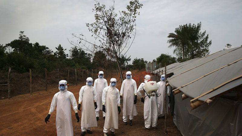 A burial team awaits decontamination at the U.S.-built cemetery for 