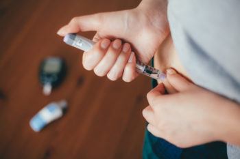 woman performing an injection with insulin pen