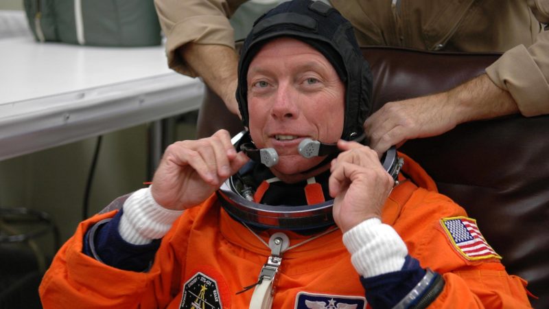 Michael Fossum is helped with his launch suit
