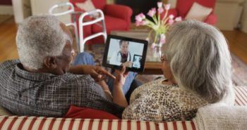 Elderly couple watches an iPad that features a doctor reviewing an x-ray