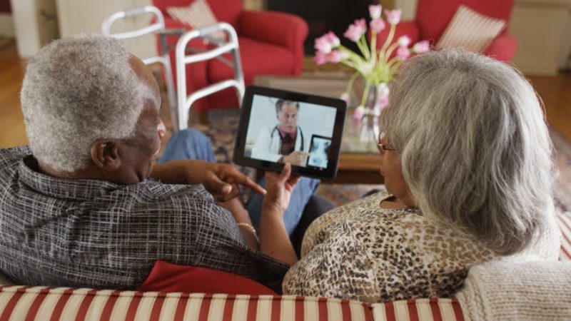 Elderly couple watches an iPad that features a doctor reviewing an x-ray