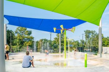 Children play at a splash pad at the Fun For All Playground.