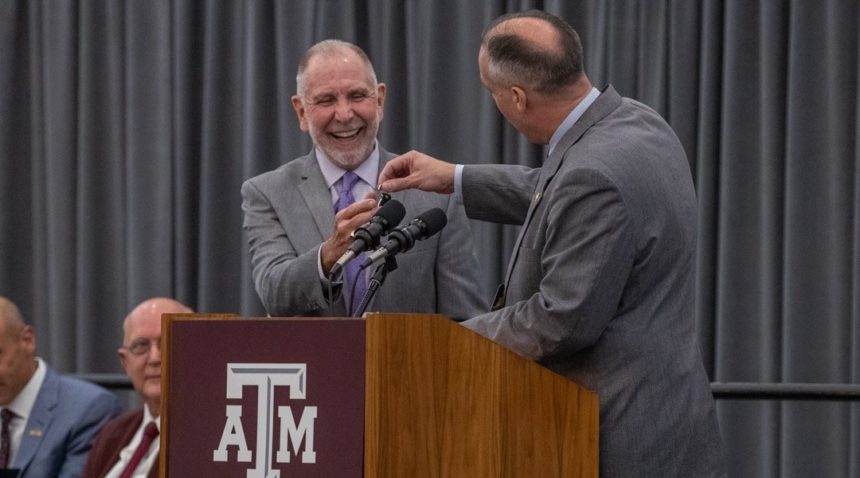 Timothy Rhea, director of bands and music activities, hands University President Michael K. Young a key to a locker in the new Music Activities Center.