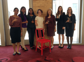 Women of IT conference attendees pose with a red chair