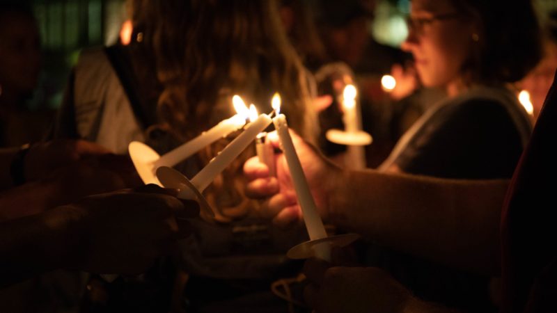 Lighting candles at night during the the 2018 Suicide Awareness Walk.