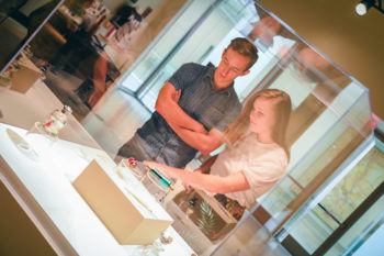 Students view glass encased art exhibit