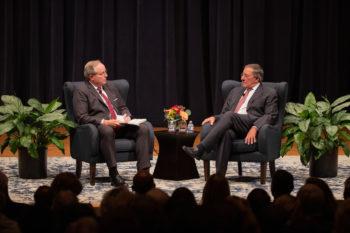 Mark A. Welsh sits on a stage with Leon Panetta