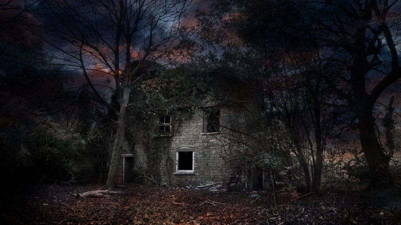 Abandoned old cottage in woodland at night