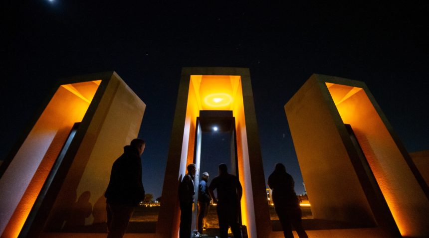 visitors to the bonfire memorial silhoutted against the portals