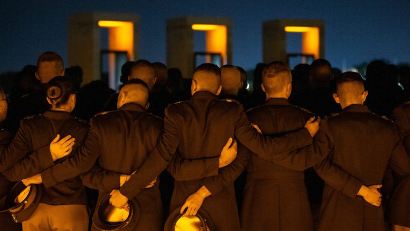 Corps students at Bonfire Memorial with arms around each other