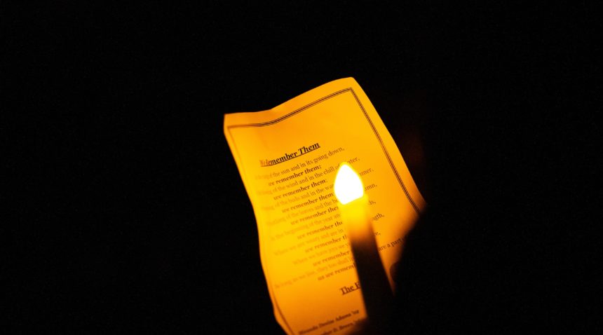 lit candle in front of a program at the bonfire remembrance ceremony