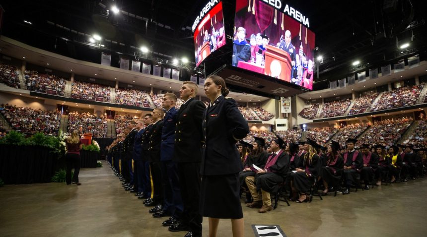 cadets stand in a line in reed arena at the front of the graduation ceremony