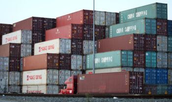 shipping containers stacked at the port of los angeles, some marked "china shipping"