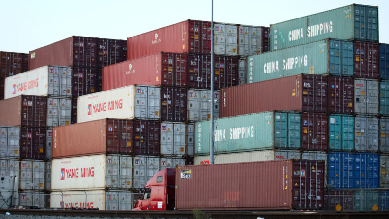 shipping containers stacked at the port of los angeles, some marked 