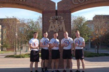 The five Texas A&M students of Project Atlas posing with thumbs up in the Corps of Cadets quad on campus