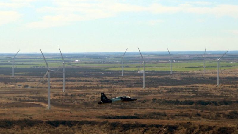 A jet flies near wind turbines in West Texas.