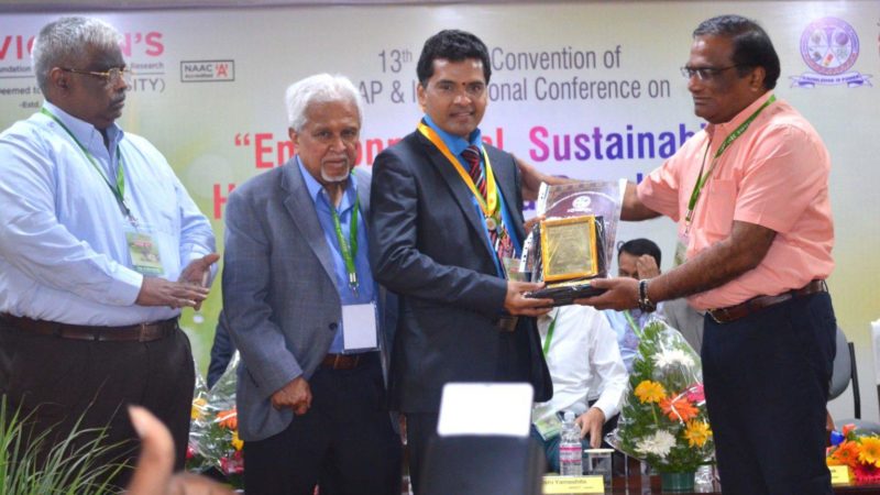 samba reddy holding a plaque at a conference