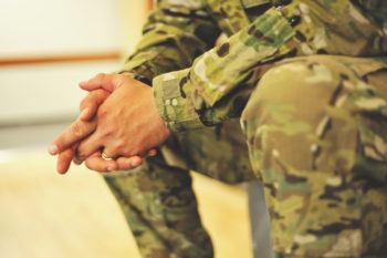 close up image of the hands of a soldier dressed in uniform