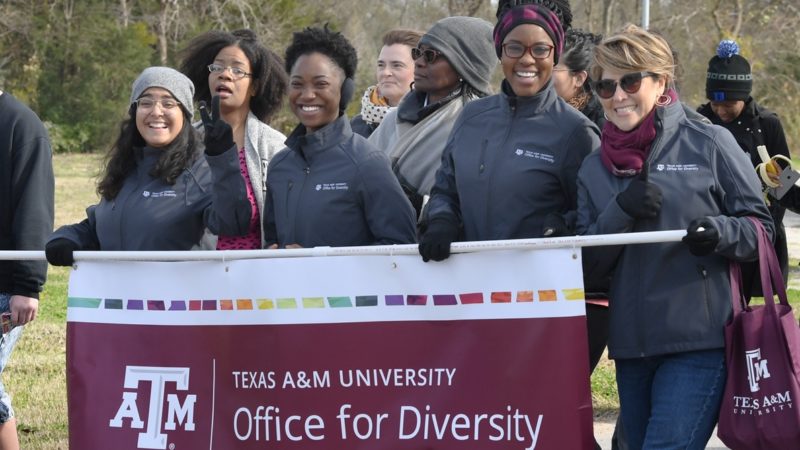 staff members from Texas A&M's Office for Diversity walking in the 2019 MLK march, holding a banner with the name of their office