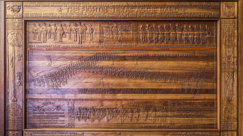 close up view of wood relief sculpture detailing history of aggie band