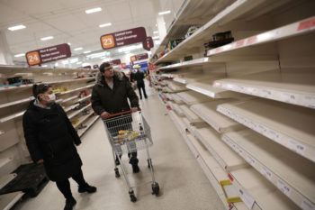 shoppers looking at empty shelves in super market
