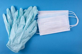 Medical masks and gloves on a blue background.