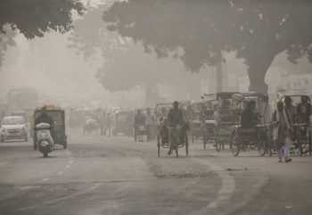traffic on a street amid heavy dust and fog in india