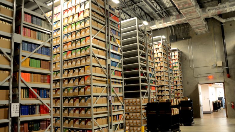 a warehouse filled with tall shelves of manuscripts and books