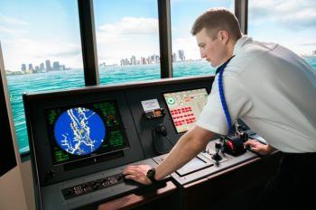maritime academy cadet in uniform using ship simulator