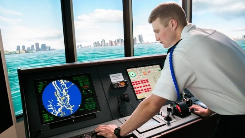 maritime academy cadet in uniform using ship simulator