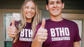 two students wearing BTHO coronavirus shirts give the gig 'em sign