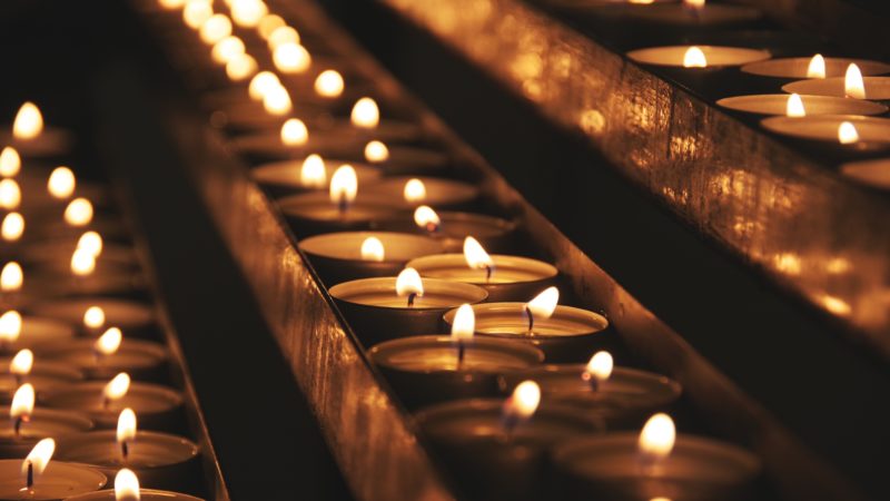 a group of lit votive candels