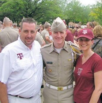 Taylor in Corps uniform standing between parents