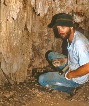 photo of professor in cave collecting snail samples