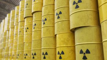 yellow barrels of nculear waste stacked in warehouse