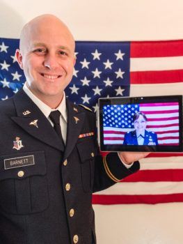 don barnett in uniform in front of american flag holding an ipad with his sister on the screen