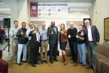 faculty members standing in line giving gig'em sign