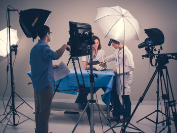 view of lighting and video equipment set up in front of a table where two veterinary educators are being filmed