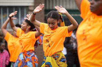 girls in yelow t shirts dance during a parade